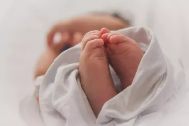 baby covered with white blanket